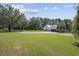 Expansive lawn featuring home, a long driveway, and a separate garage with an outdoor basketball court at 62 Warbler St., Georgetown, SC 29440