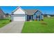 Charming blue one-story home featuring a well-manicured lawn and attached two-car garage at 622 Castillo Dr., Loris, SC 29569