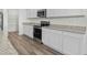 Modern kitchen with white cabinets, gray countertops, and stainless steel appliances at 622 Castillo Dr., Loris, SC 29569