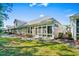 View of the rear exterior of the home showing the sunroom and yard at 6244 Catalina Dr. # 511, North Myrtle Beach, SC 29582