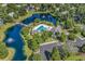 Community aerial view showcasing a lake, swimming pool, clubhouse, and parking area at 67 Camden Circle, Pawleys Island, SC 29585