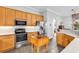 Well-lit kitchen with stainless steel appliances, tile backsplash, and wood butcher block island for food preparation at 67 Camden Circle, Pawleys Island, SC 29585