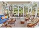 Bright sunroom with multiple windows, stylish furnishings, and tranquil views of the surrounding landscape at 67 Camden Circle, Pawleys Island, SC 29585