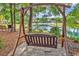 Wooden swing overlooking the pond and a bridge in a landscaped garden setting at 67 Camden Circle, Pawleys Island, SC 29585