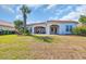 Expansive backyard with healthy green grass leading up to a house with white pillars at 7202 Seville Dr., Myrtle Beach, SC 29572