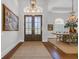 Elegant foyer featuring a double-door entrance, hardwood floors, a jute rug, and decorative chandelier at 7202 Seville Dr., Myrtle Beach, SC 29572