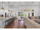Bright, open-concept living space with a granite kitchen island and expansive windows overlooking the lush backyard at 7202 Seville Dr., Myrtle Beach, SC 29572