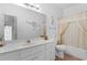 Bathroom features a vanity, toilet, and shower/tub with decorative curtains and a large mirror at 728 Churchill Dr., Myrtle Beach, SC 29579
