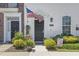Close-up of the front entrance with black door, American flag, and decorative landscaping at 815 Murray Ave., Myrtle Beach, SC 29577
