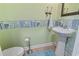 Quaint powder room featuring pastel wallpaper, a pedestal sink, and tiled flooring at 815 Murray Ave., Myrtle Beach, SC 29577