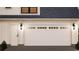 A well-maintained garage featuring a white door with decorative windows and carriage lights at 9 Sw Mashie Ct., Carolina Shores, NC 28467
