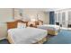 Cozy bedroom with two beds, a balcony, and a nightstand with a lamp for a relaxing stay at 9820 Queensway Blvd. # 804, Myrtle Beach, SC 29572