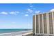 Exterior view of a high-rise building along a beautiful beach on a sunny day with a fishing pier in the distance at 9820 Queensway Blvd. # 804, Myrtle Beach, SC 29572