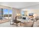 Bright living room featuring a comfortable couch and views of the ocean from the large windows at 9820 Queensway Blvd. # 804, Myrtle Beach, SC 29572