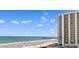 Beautiful ocean view highlighting the beach with blue umbrellas and a pier in the distance at 9820 Queensway Blvd. # 804, Myrtle Beach, SC 29572