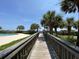 Scenic wooden walkway surrounded by lush greenery and palm trees, leading to the beach and pool at 9820 Queensway Blvd. # 804, Myrtle Beach, SC 29572
