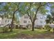 Rear exterior view of elevated houses with trees and landscaped yards at 108 N Oak Dr., Surfside Beach, SC 29575