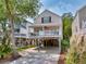 Charming elevated beach home featuring a front porch and convenient ground-level parking at 108 N Oak Dr., Surfside Beach, SC 29575