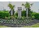 The Sanctuary community entrance features lush landscaping, palm trees, and seasonal flowers at 1141 Prescott Circle, Myrtle Beach, SC 29577