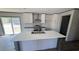 This kitchen features white cabinets, stainless steel appliances, an island with a sink, and a sliding glass door at 1300 Rabbit Ln., Conway, SC 29526
