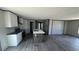 White kitchen featuring an island with sink, stainless steel appliances, dark countertops, and laminate flooring at 1300 Rabbit Ln., Conway, SC 29526