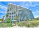 Large resort building with balconies and palm trees at 1501 S Ocean Blvd. # 1232, Myrtle Beach, SC 29577