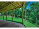 Covered patio with a peaceful view of the green lawn and surrounding trees at 1673 Carriage Ln., Little River, SC 29566