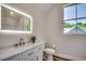 Well-lit bathroom featuring a sleek lighted mirror, elegant white vanity, and a toilet with coordinated décor at 1673 Carriage Ln., Little River, SC 29566