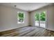 Bright bedroom featuring wood floors and access to a deck via sliding glass doors, offering views of the verdant landscape at 1673 Carriage Ln., Little River, SC 29566