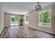 Bright, open living room featuring hardwood floors, large windows, and a sliding glass door to the balcony at 1673 Carriage Ln., Little River, SC 29566
