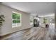 Open-concept living space with wood floors, large windows, and a modern kitchen, perfect for entertaining and relaxation at 1673 Carriage Ln., Little River, SC 29566