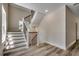 Stylish staircase with modern wood and metal railings, complemented by durable wood flooring at 1673 Carriage Ln., Little River, SC 29566
