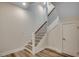 Modern staircase with light wood steps and black metal railings, next to a white door, in a neutrally decorated home at 1673 Carriage Ln., Little River, SC 29566