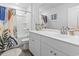 Bright bathroom with white vanity, decorative mirror and shower with colorful curtains at 205 Marsh Deer Place, Surfside Beach, SC 29575
