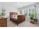 Cozy bedroom with a wood sleigh bed, plantation shutters and indoor plants at 205 Marsh Deer Place, Surfside Beach, SC 29575