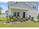 Inviting front porch with beautiful landscaping and cozy seating area perfect for relaxation at 205 Marsh Deer Place, Surfside Beach, SC 29575