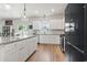 Kitchen with white cabinets, stainless steel appliances, granite countertops, and hardwood floors at 205 Marsh Deer Place, Surfside Beach, SC 29575