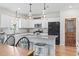 Open kitchen features white cabinets, granite countertops, stainless steel appliances, and pendant lighting at 205 Marsh Deer Place, Surfside Beach, SC 29575