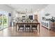 Dining area with an adjacent modern white kitchen, stainless steel appliances, and stylish pendant lighting at 205 Marsh Deer Place, Surfside Beach, SC 29575