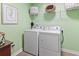 Functional laundry room featuring a white washer and dryer with overhead shelving at 205 Marsh Deer Place, Surfside Beach, SC 29575