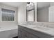 Bathroom with double sink vanity, gray cabinets, marble countertop, and soaking tub at 2072 Haystack Way, Myrtle Beach, SC 29579