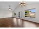 Open living room with high ceilings, hardwood floors, large windows, and a glass front door at 2072 Haystack Way, Myrtle Beach, SC 29579