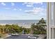 Beach view from a balcony showing trees, parking, a wooden walkway, and the ocean at 210 N Ocean Blvd. # 333, North Myrtle Beach, SC 29582