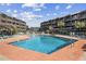 Community pool featuring lounge chairs, a sunning deck, and beautiful landscaping between condo buildings at 210 N Ocean Blvd. # 333, North Myrtle Beach, SC 29582