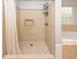 Walk-in shower with beige tiles, built-in niche, and a glass-block window at 249 Ashepoo Creek Dr., Myrtle Beach, SC 29579