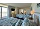 Comfortable bedroom features two beds, a TV, balcony access, and calming decor at 2801 S Ocean Blvd. # 1041, North Myrtle Beach, SC 29582