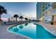 Beautifully designed outdoor pool area with clear water, palm trees, and poolside seating by the building at 2801 S Ocean Blvd. # 1634, North Myrtle Beach, SC 29582