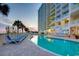 Resort style pool surrounded by lounge chairs next to a tall condo building with ocean views at sunset at 2801 S Ocean Blvd. # 1634, North Myrtle Beach, SC 29582
