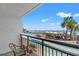 Balcony view of a resort pool area, beach, palm trees, lounge chairs, and a clear blue sky at 3000 N Ocean Blvd. N # 129, Myrtle Beach, SC 29577