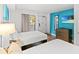 Cozy bedroom with two beds, ocean-themed artwork, and natural light from the sliding glass door at 3000 N Ocean Blvd. N # 129, Myrtle Beach, SC 29577